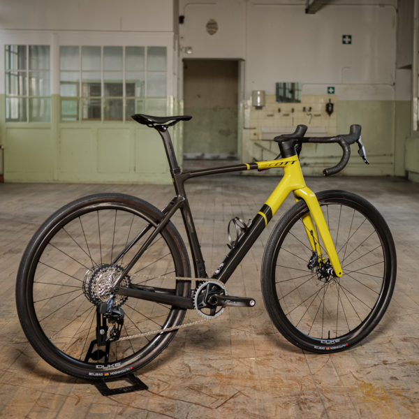 Vélo de gravel SCOTT dans un atelier industriel. Vue de 3/4 arrière